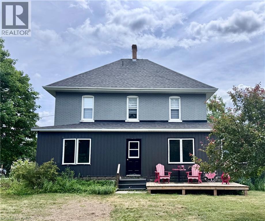 31 BLUE BAY Lane=Back of house with a shingled roof, a deck, a lawn, a chimney, and an outdoor living space