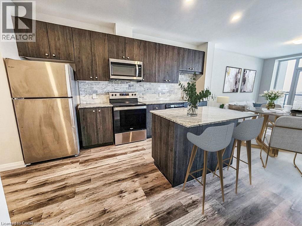 104 GARMENT Street Unit# 1602=Kitchen featuring stainless steel appliances, a kitchen breakfast bar, dark brown cabinets, and light hardwood / wood-style flooring