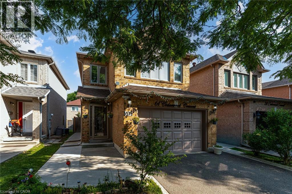 61 CEDARWOOD Crescent=View of front of property featuring an attached garage, driveway, and stone siding