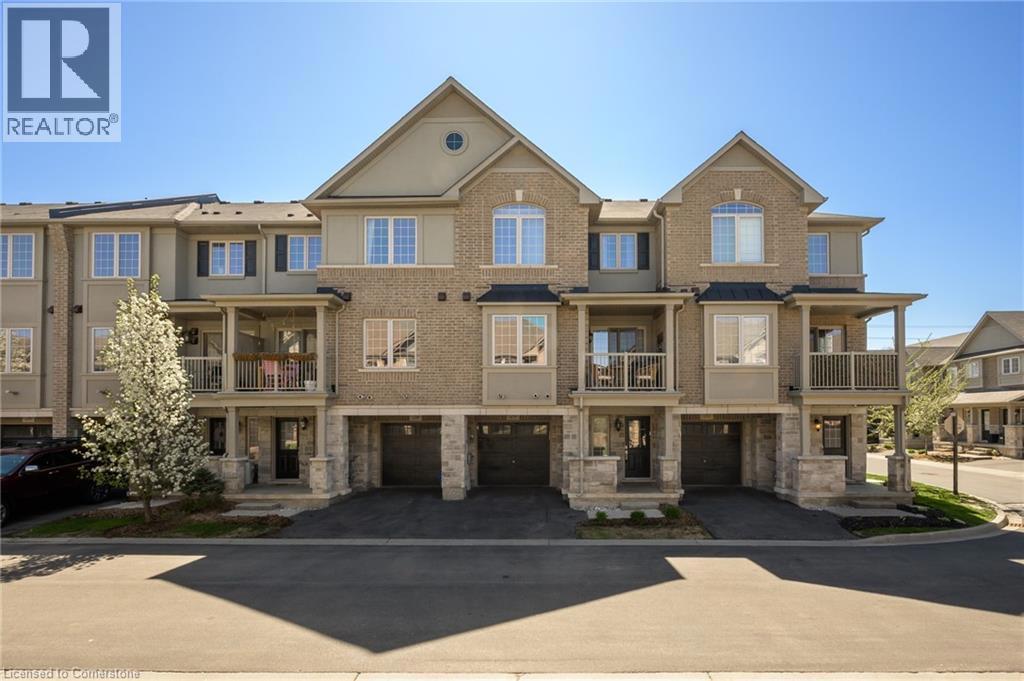 215 DUNDAS Street E Unit# 29=View of front of property featuring brick siding, an attached garage, a balcony, driveway, and a residential view