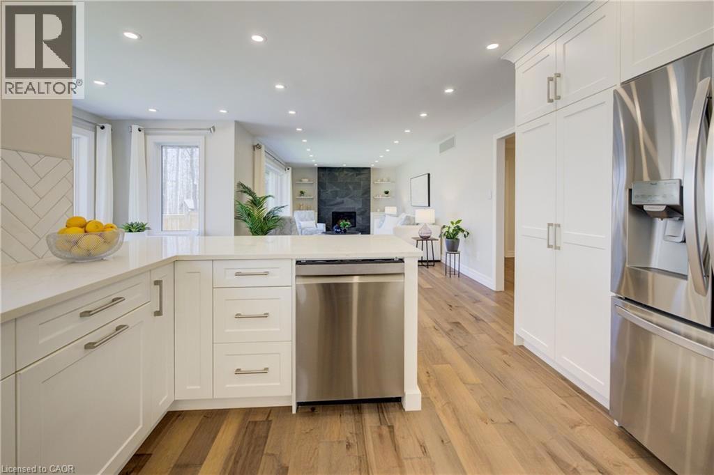 439 NORTHLAKE Drive=Kitchen featuring stainless steel appliances, white cabinetry, open floor plan, recessed lighting, and light stone countertops