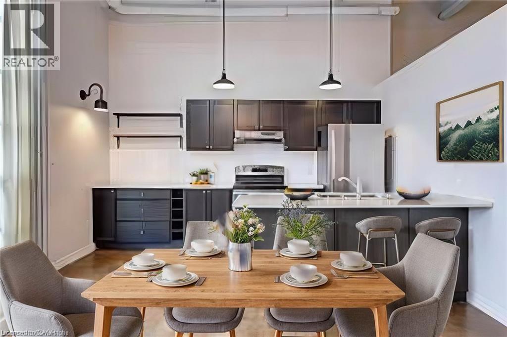 11 REBECCA Street=Kitchen with a towering ceiling, dark brown cabinets, a peninsula, decorative light fixtures, and appliances with stainless steel finishes